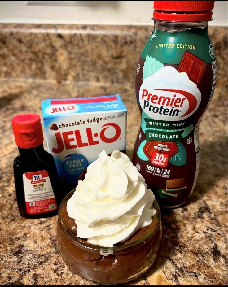 the ingredients to make chocolate pudding are sitting on the counter top, including whipped cream and jello