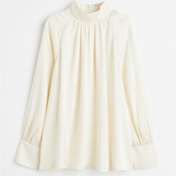 Blouse In Softly Draped Satin. Stand-Up Collar, Keyhole Opening At Back Of Neck With Covered Buttons, And Long, Raglan-Cut, Balloon Sleeves With Covered Buttons At Cuffs. Straight-Cut Hem. Size: Back: Length: 66.0 Cm (Size M), Sleeve: Length: 73.3 Cm (Size M) Spring High Neck Blouse For Work, Fitted Tops With Pleated Sleeves For Daywear, High Neck Blouse For Spring Workwear, Feminine Fitted Top With Pleated Sleeves, White Lantern Sleeve Tops For Fall, White Lantern Sleeve Top For Fall, White Blouse For Fall Daywear, White Long Sleeve Top For Work, Cream Bishop Sleeve Top For Spring