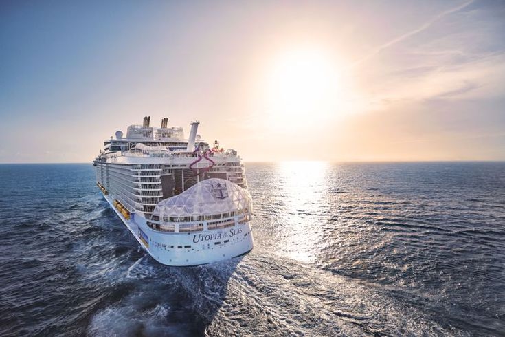 a large cruise ship in the middle of the ocean with sun shining on it's side