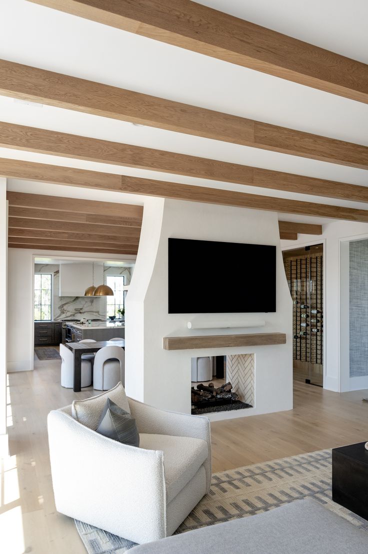 a living room with white couches and a flat screen tv mounted on the wall