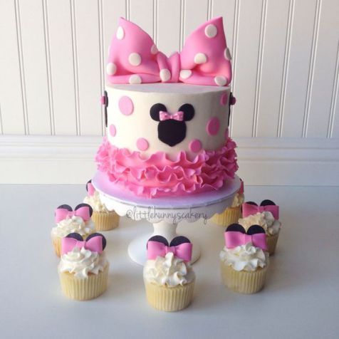 a minnie mouse cake and cupcakes on a table