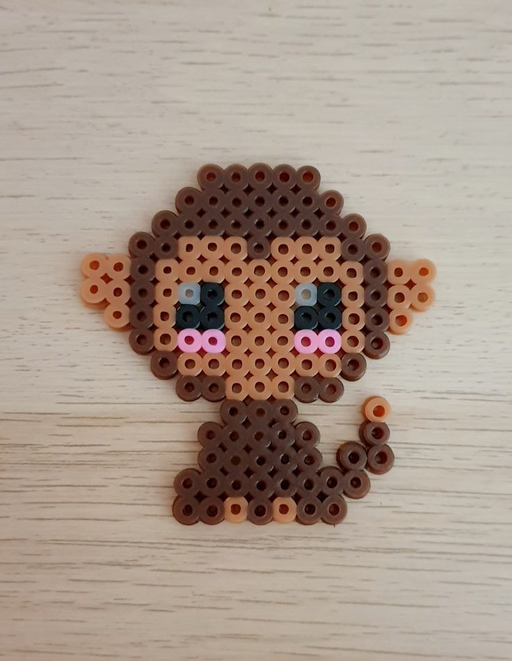 a bead doll made to look like it is wearing a brown outfit and pink nose