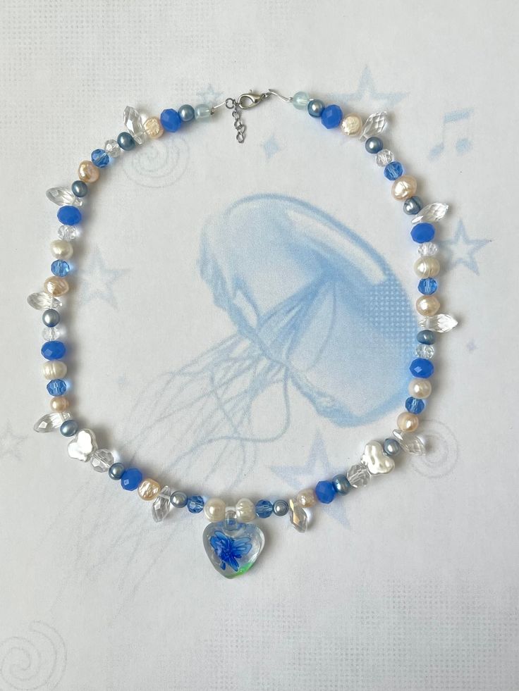 blue jellyfish inspired necklace 💙🫧 super cute for the summer or any type of occasion! made with murano glass heart pendant, fresh water pearl beads and rondelle crystals beads <3 necklace is approximately 16 inches but has a chain at the end to adjust length!  Canadian Orders 🇨🇦  this order is eligible for free shipping through untracked lettermail however I cannot refund/replace lost or stolen items with no tracking number due to Etsy's policies, so please keep that in mind when selecting Blue Heart-shaped Beaded Chain Jewelry, Blue Heart Necklace With Colorful Beads, Blue Heart-shaped Necklace With Colorful Beads, Blue Heart Beaded Necklaces, Heart-shaped Summer Necklaces Perfect As Gifts, Heart Shaped Necklaces For Summer Gifts, Adjustable Blue Heart-shaped Beaded Necklaces, Adjustable Blue Heart-shaped Beaded Necklace, Adjustable Blue Heart Beaded Necklaces