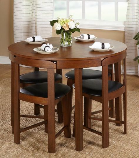 a wooden table with four chairs and a vase filled with flowers on top of it