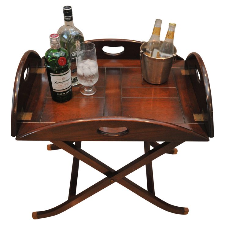 a wooden tray with bottles and glasses on it sitting on top of a table next to a wine glass