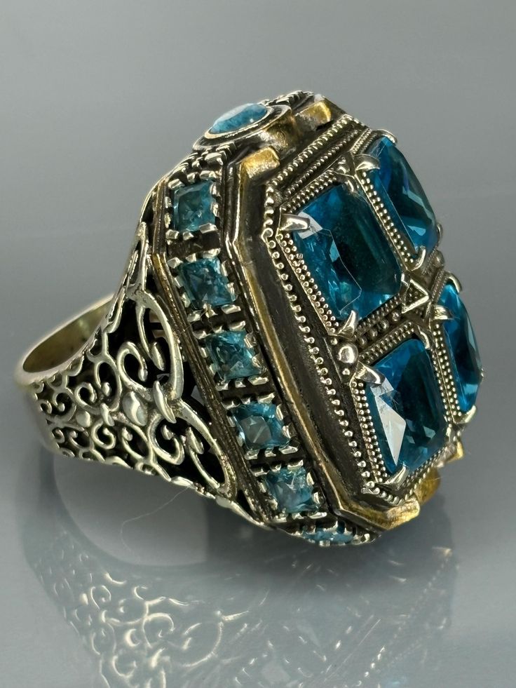 Embrace the allure of the past with our Mystic Aqua Blue Silver Ring. This striking piece is a nod to vintage sophistication, designed to stand out as a bold statement. Artisan-crafted with attention to detail, it features an enchanting green stone at its heart, complemented by intricate sterling silver work. We offer free ring resizing service for our rings, all you need to do is leaving message after you complete your payment. Material=  925 Sterling Silver   Stone/Stones=Aquamarine Ring Size(US)= 10 Weight(gr)=40.3 Coating=None   Resizing (For Free)=8 -16(US) Item Specify=Special Handmade Design Vintage Charm: Inspired by antique designs for a timeless appeal. Aquamarine Gemstone: A deep emerald gem that captivates and adds a touch of mystery. Sterling Silver: High-quality sterling silv Vintage Ceremonial Ring Jewelry, Vintage Ceremonial Ring, Vintage Rings With Intricate Design, Vintage Signet Ring With Lost Wax Casting As Gift, Antique Handmade Signet Ring Collectible, Vintage Engraved Ring Stamped 925 As Gift, Vintage Engraved Ring Stamped 925 For Gift, Vintage Sterling Silver Signet Ring Gift, Vintage Signet Ring With Intricate Design For Anniversary