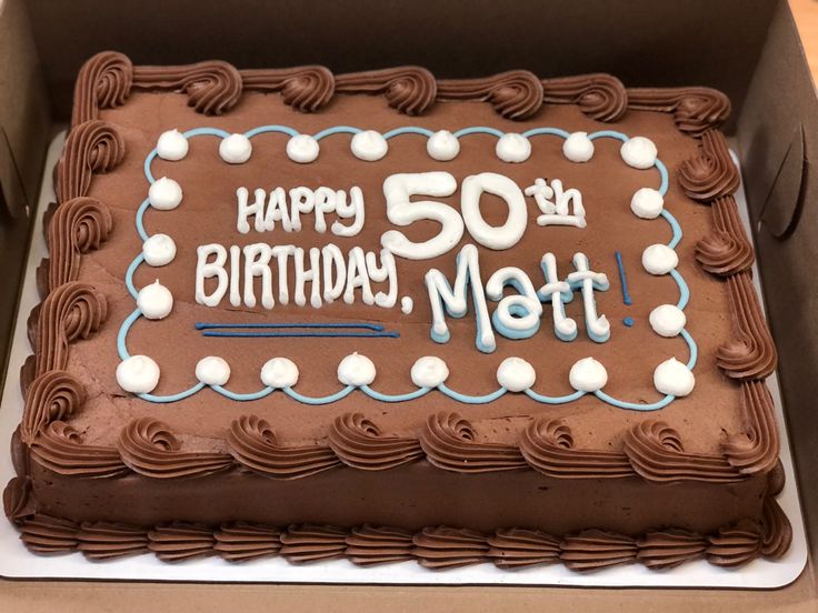 a chocolate birthday cake with white frosting and the words happy 50th matt on it