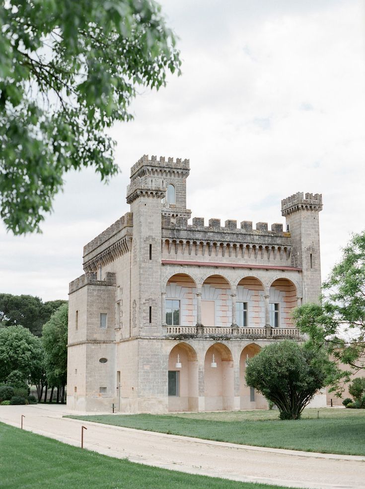 an old castle like building sitting on top of a lush green field