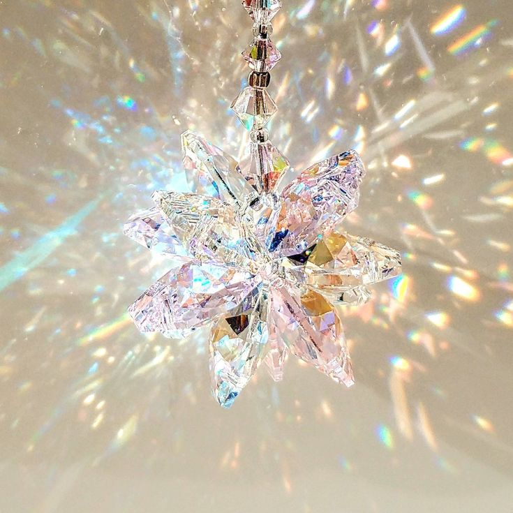 a snowflake ornament hanging from a chain on a white background with holographics