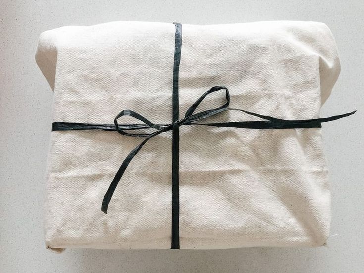 a wrapped gift box with black ribbon on it