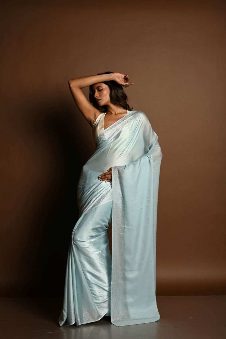 This stunning ice blue satin saree is adorned with elegant stonework, making it perfect for special occasions. Embrace timeless beauty with this luxurious piece. Bollywood Style Light Blue Blouse Piece With Traditional Drape, Elegant Blue Pre-draped Saree For Designer Wear, Luxury Light Blue Designer Saree, Formal Unstitched Dola Silk Saree, Light Blue Art Silk Traditional Wear For Wedding, Formal Blue Saree Set, Wedding Saree In Light Blue With Cutdana, Elegant Blue Saree Set, Elegant Designer Blue Pre-draped Saree