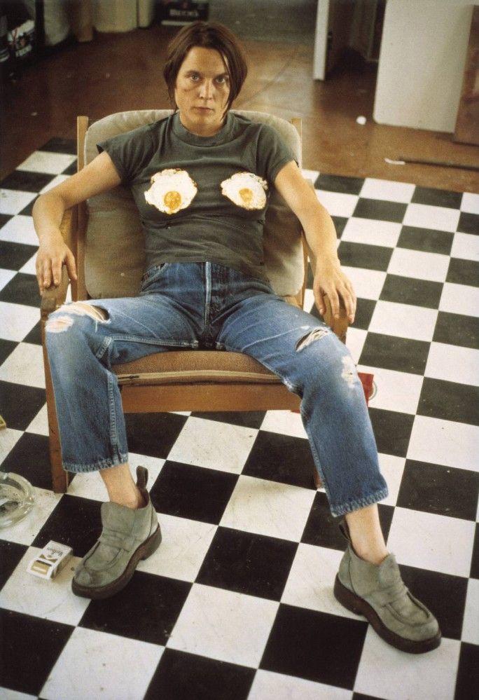 a man sitting in a chair with an egg on his shirt and some other shoes