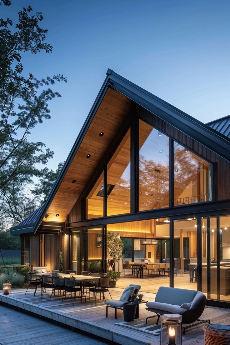 a house that is sitting on top of a wooden deck with chairs and tables in front of it