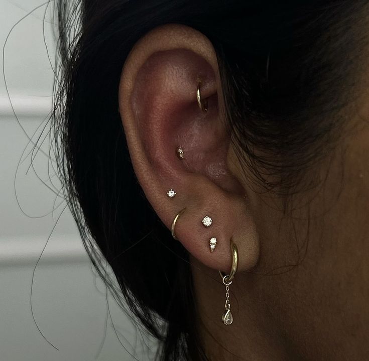 a close up of a person's ear with three different types of piercings