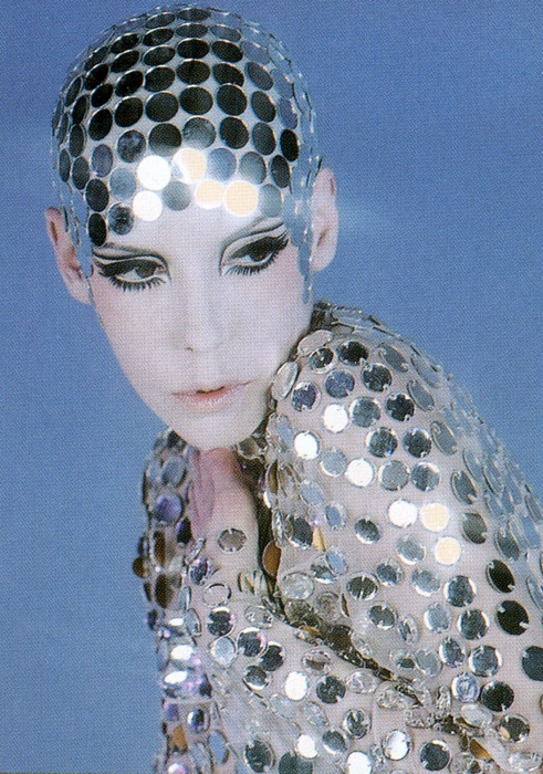 a woman with sequins on her face and hair is posing for the camera