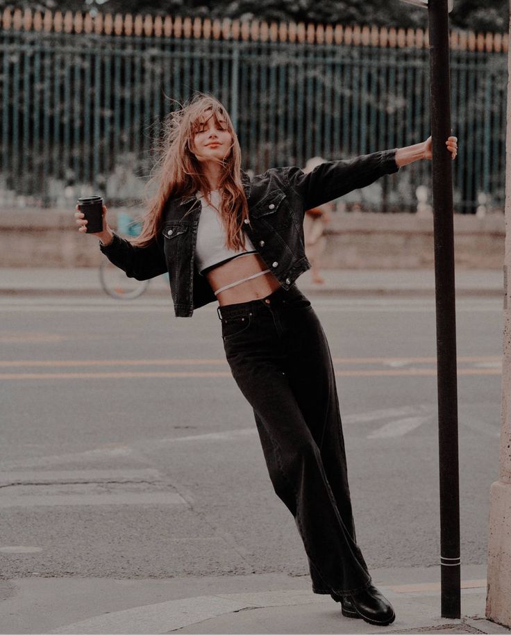 a woman leaning on a pole with her arms outstretched