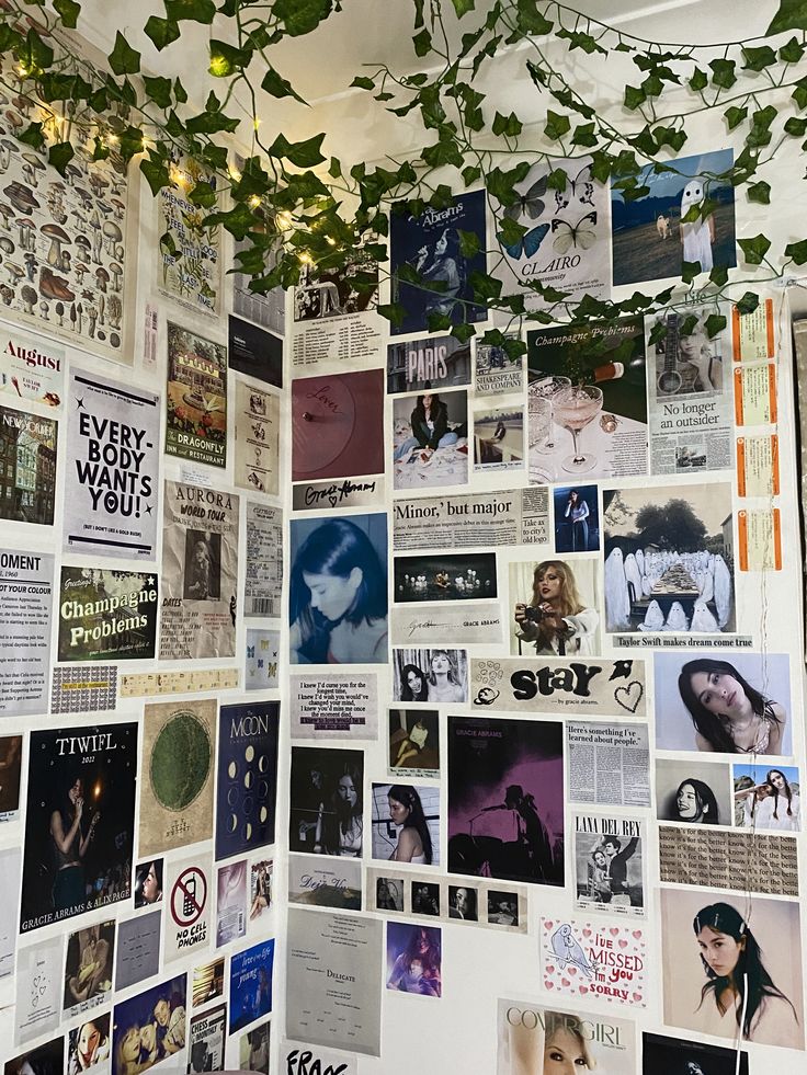 the wall is covered with posters and ivy growing from it's ceiling, along with hanging lights