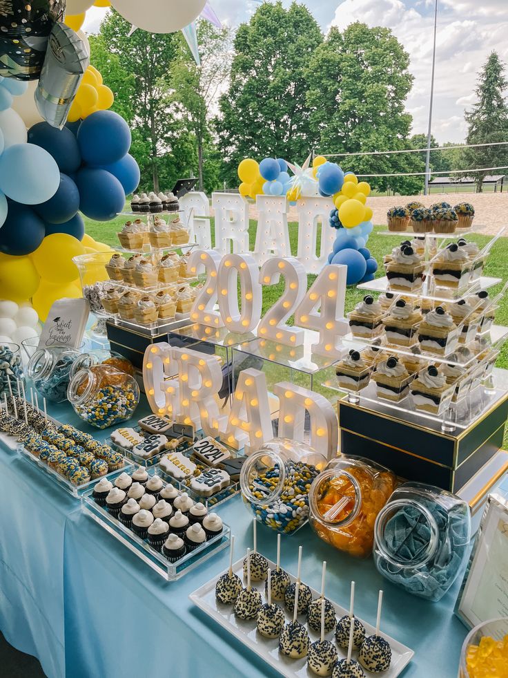 a table topped with lots of desserts and balloons