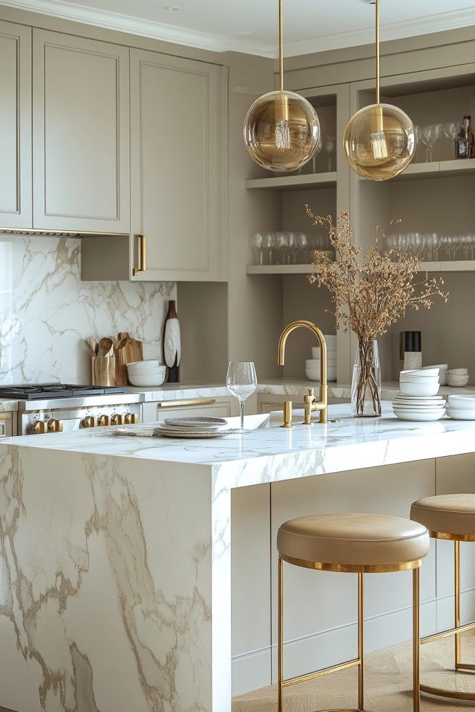 a kitchen with marble counter tops and gold accents on the cabinets, along with two bar stools