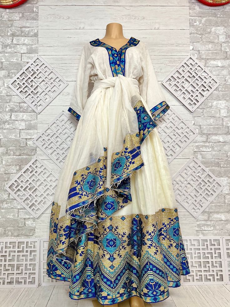 Beautiful Ethiopian and Eritrean Habeshan Dress. Stylish Menen, 100% Cotton We recommend hand washing and air drying to make it last longer. A low heating iron will also keep design and look. Beautiful Habeshan Dress |Ethiopian Traditional Dress|Eritrean Dress|Habesha Kemis|Zuria|Habesha Chiffon|Kemis Blue Ethiopian Dress, Gold Habesha Kemis, Habesha Traditional Dresses, Eritrean Traditional Dress, Ethiopia Traditional Clothing, Eritrean Zuria Dresses, Modern Ethiopian Dress, Silk Anarkali Long Sleeve Kaftan, Silk Anarkali Kaftan With Long Sleeves