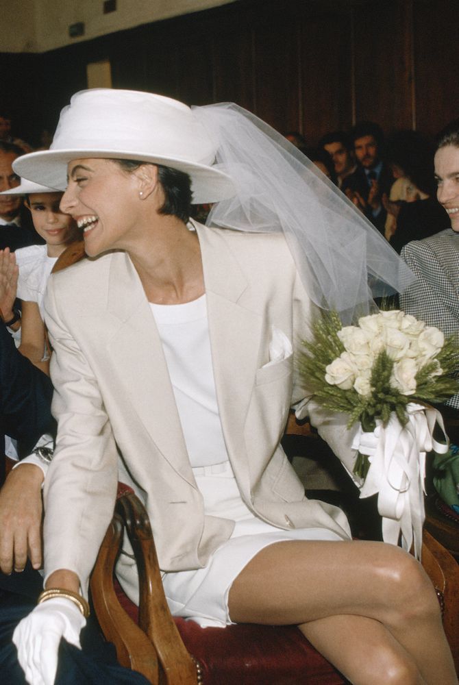 a woman sitting in a chair wearing a white hat