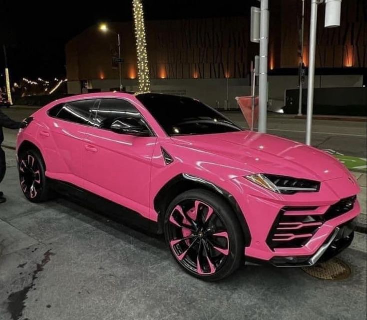 a pink lamb suv parked on the street