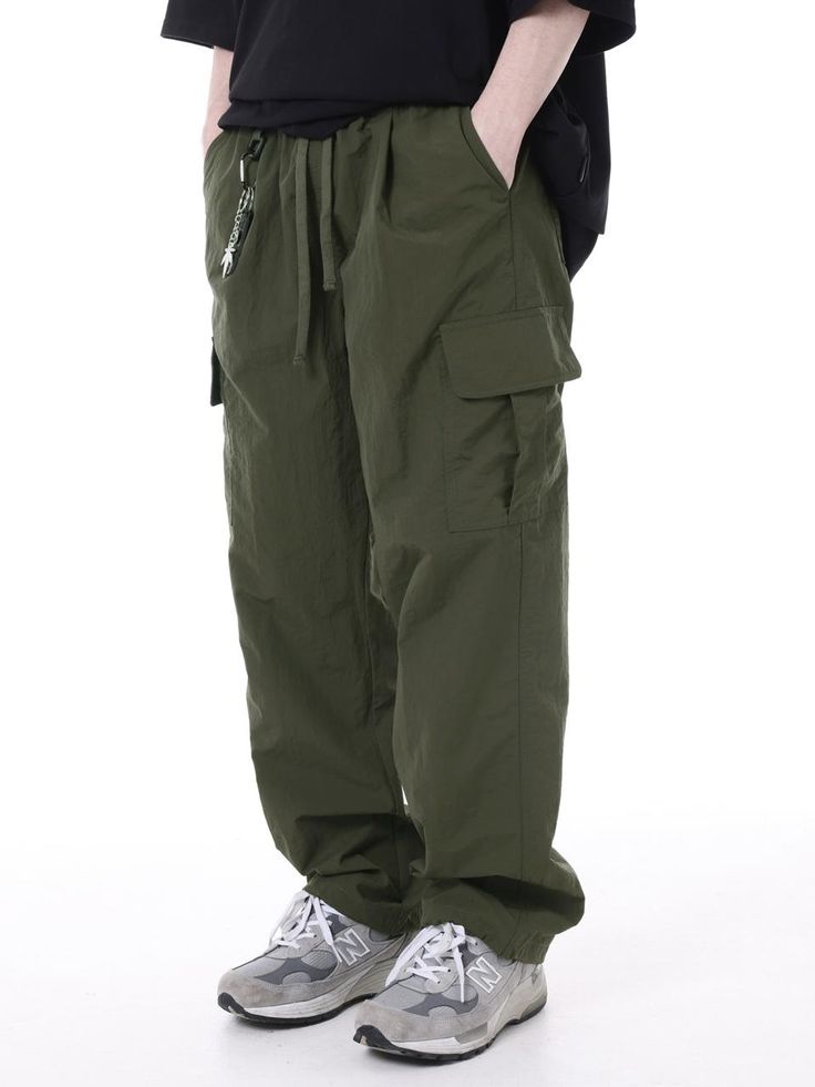 It is string cargo pants with the 100% nylon fabric. You can adjust the size with the waist string. You can wear it casually. - Wide fit - Waist banding- Pin tuck detail on the front thigh- Cargo pockets- Stopper on the hem Utility Khaki Cargo Pants With Elastic Waistband, Utility Cargo Pants With Elastic Waistband In Khaki, Military Style Relaxed Fit Cargo Pants With Elastic Waistband, Urban Style Khaki Parachute Cargo Pants, Khaki Combat Style Parachute Pants, Green Nylon Parachute Pants For Streetwear, Casual Green Nylon Parachute Pants, Urban Style Khaki Parachute Pants With Cargo Pockets, Green Military Cargo Style Parachute Pants