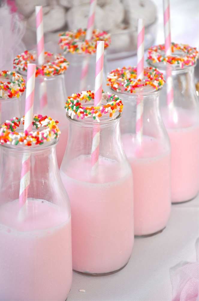 pink milk with sprinkles and straws in glass vases on table