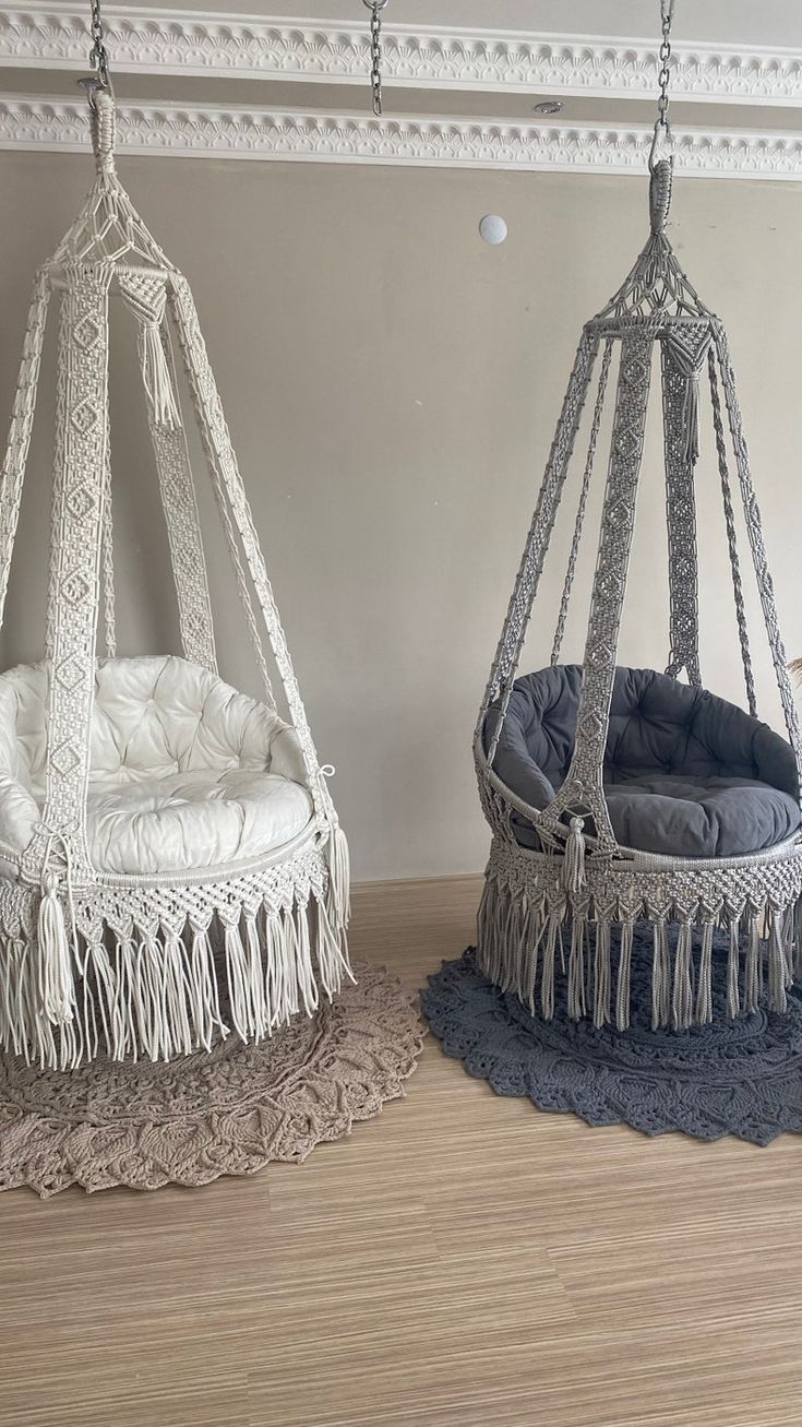 two hanging chairs with tassels on them in a living room or playroom