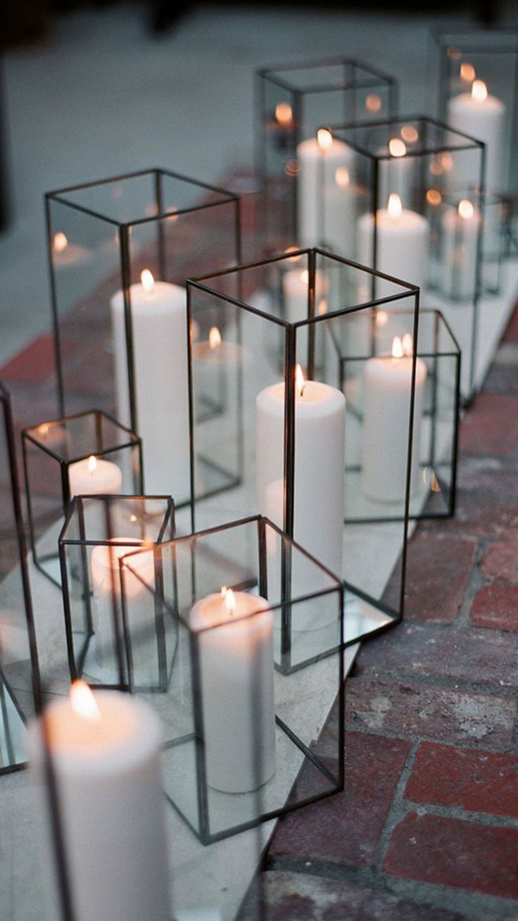 candles are arranged in glass containers on the table