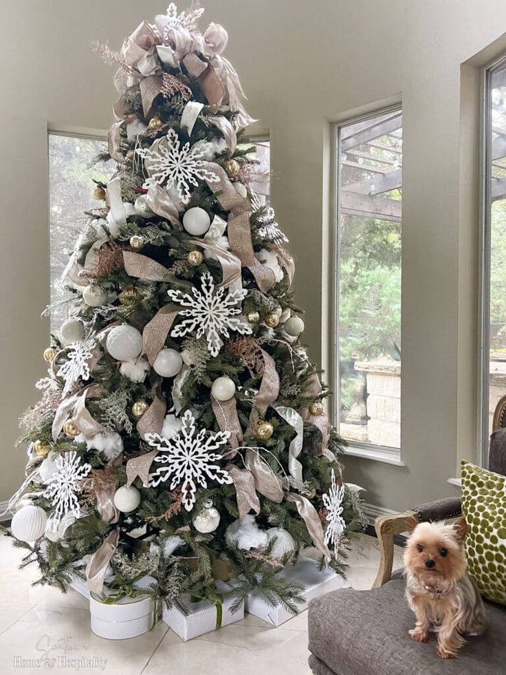 a dog sitting in front of a christmas tree