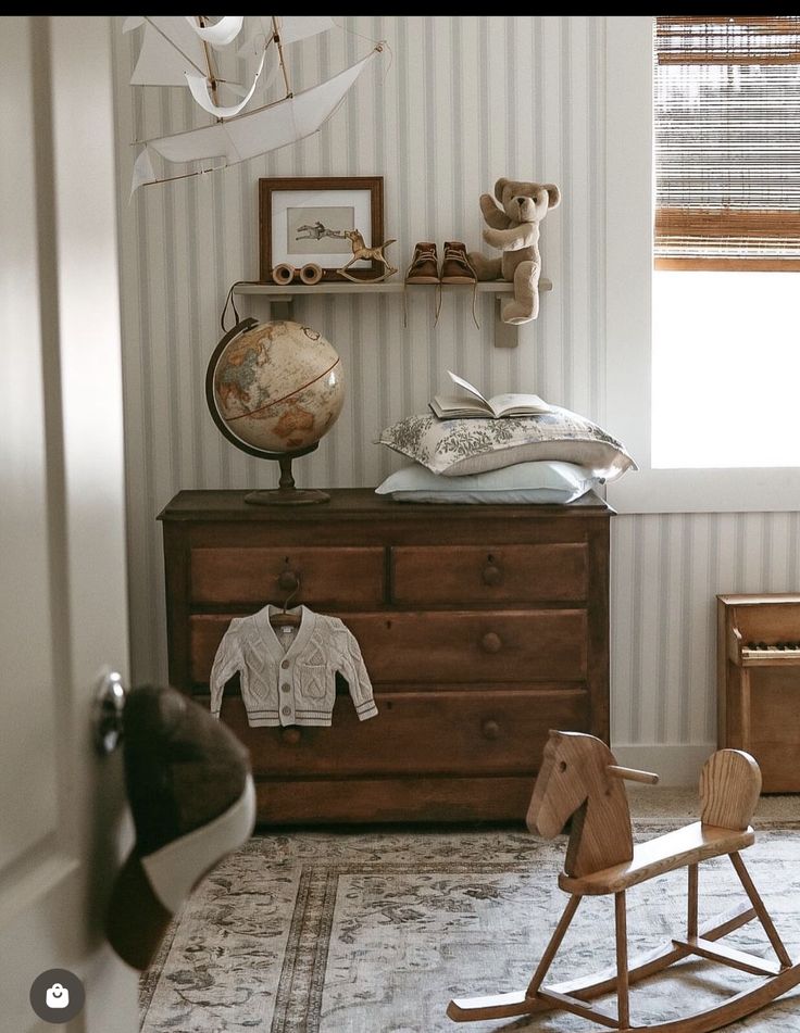 a baby's room with a rocking horse and other items on the dressers