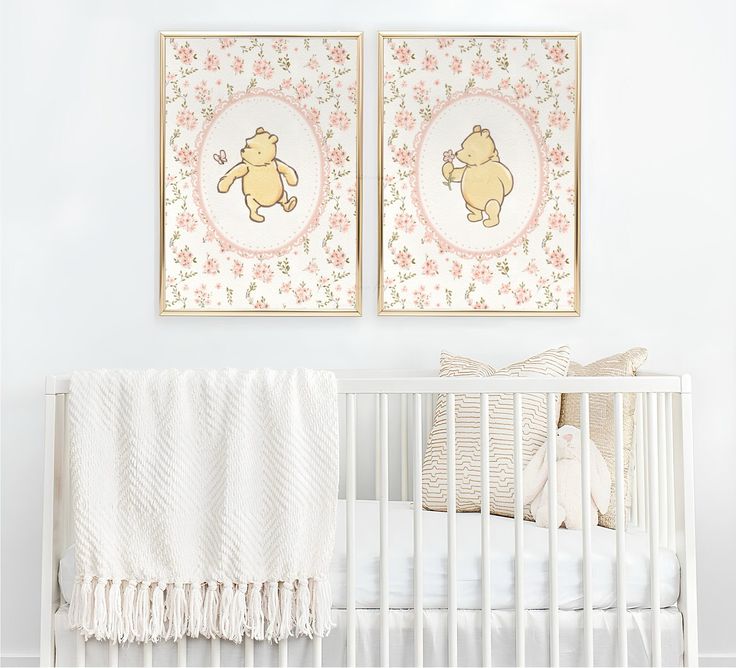 two framed pictures hang above a crib in a baby's room with pink and white decor