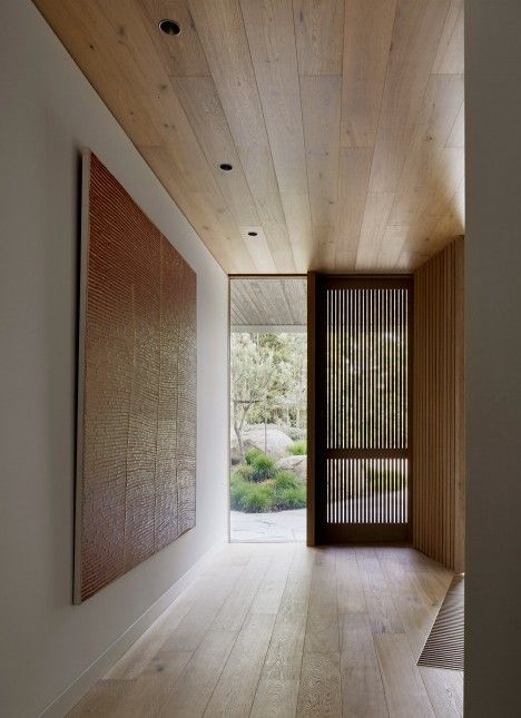 an empty hallway with wood paneling and large painting on the wall next to it