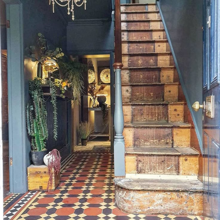 an entry way with stairs and potted plants