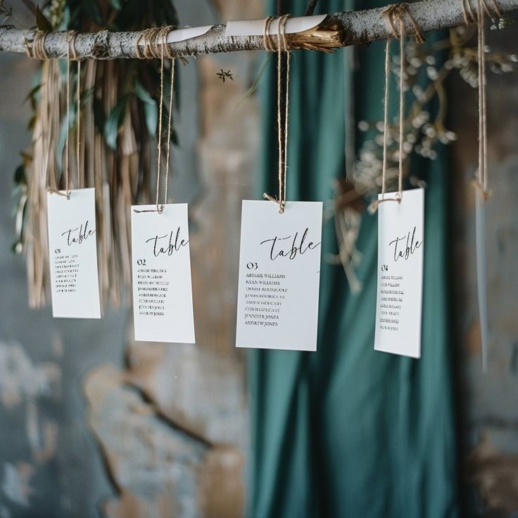 wedding seating cards hanging from a tree branch