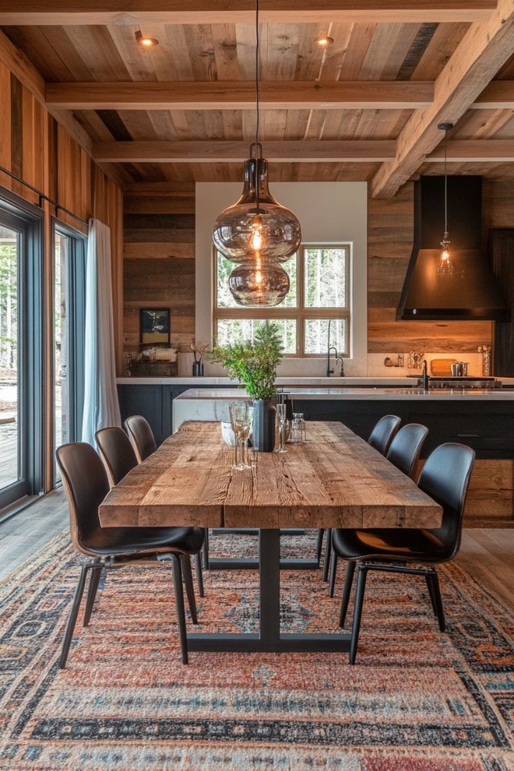 a dining room table and chairs in front of an open kitchen with wood paneling