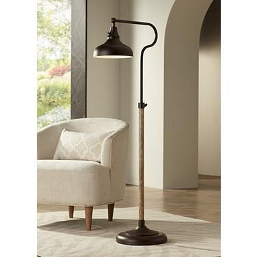 a lamp that is sitting on top of a floor next to a chair in a living room