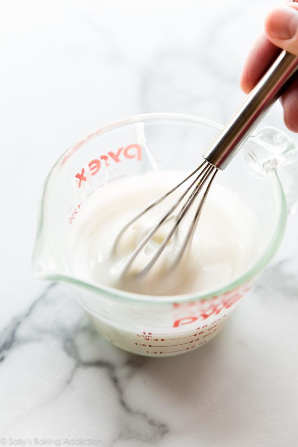 someone is whisking yogurt in a glass bowl