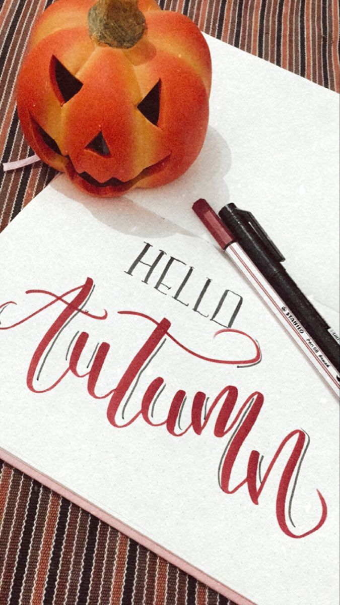 a pumpkin sitting on top of a piece of paper next to a marker and pen