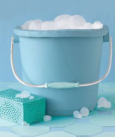 a blue bucket filled with cotton balls sitting on top of a table