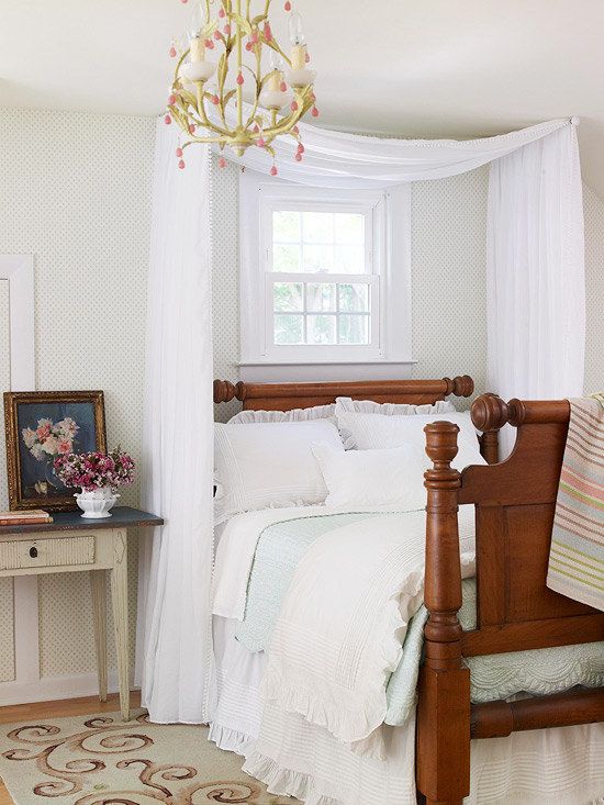 an image of a bedroom with white bedding and curtains