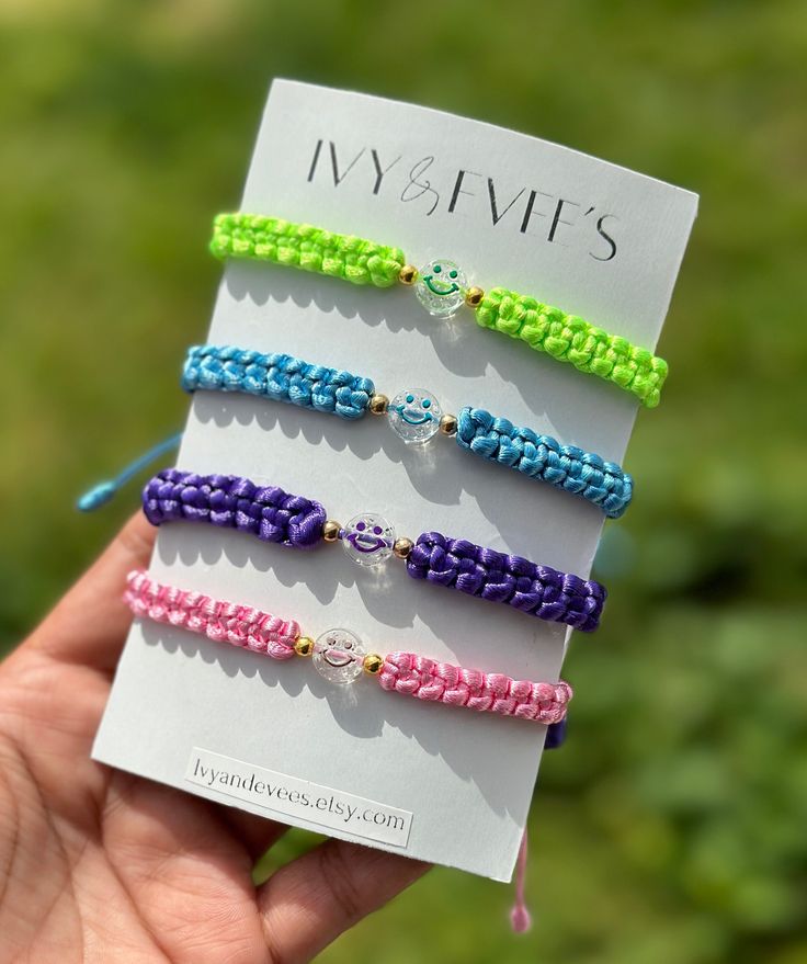 four bracelets in different colors are displayed on a card