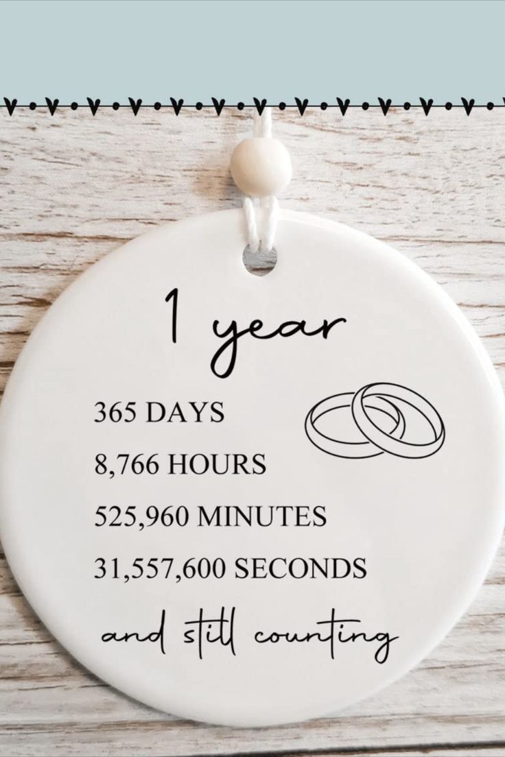 a white ceramic ornament with the date and year for each wedding ring on it