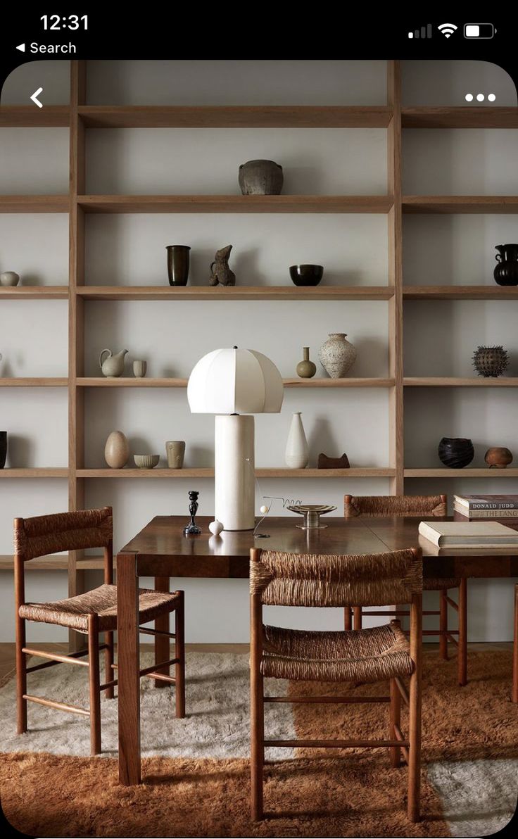 a table with chairs and shelves in the background