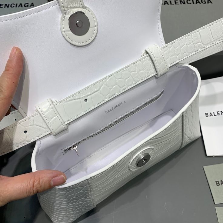 SHOP MORE LUXURY PRODUCTS HERE Description Balenciaga Downtown XS Shoulder Bag In White, For Women, Women’s Bags 10in/25cm Size:ÃƒÂ¯Ã‚Â¿Ã‚Â½ÃƒÂ¯Ã‚Â¿Ã‚Â½ÃƒÂ¯Ã‚Â¿Ã‚Â½ÃƒÂ¯Ã‚Â¿Ã‚Â½ 25 x 16 x 8.3 cm / 10 x 6.3 x 3.3 inches (Lenght x Height x Width) Curvilinear baseAdjustable and removable shoulder strapSliver hardwareMagnet closureB logo hardware1 back pocket1 inner zipped pocketWipe with a soft cloth Includes box, dust bag.This product is of the premium quality. White Baguette Bag With Top Carry Handle For Travel, Designer White Baguette Bag For Shopping, White Baguette Bag With Top Handle, White Top Handle Baguette Bag For Shopping, White Baguette Bag For Shopping, White Top Handle Baguette Bag For Errands, White Pouch Shoulder Bag With Top Carry Handle, White Pouch Bag With Top Carry Handle, White Rectangular Baguette Bag With Handles