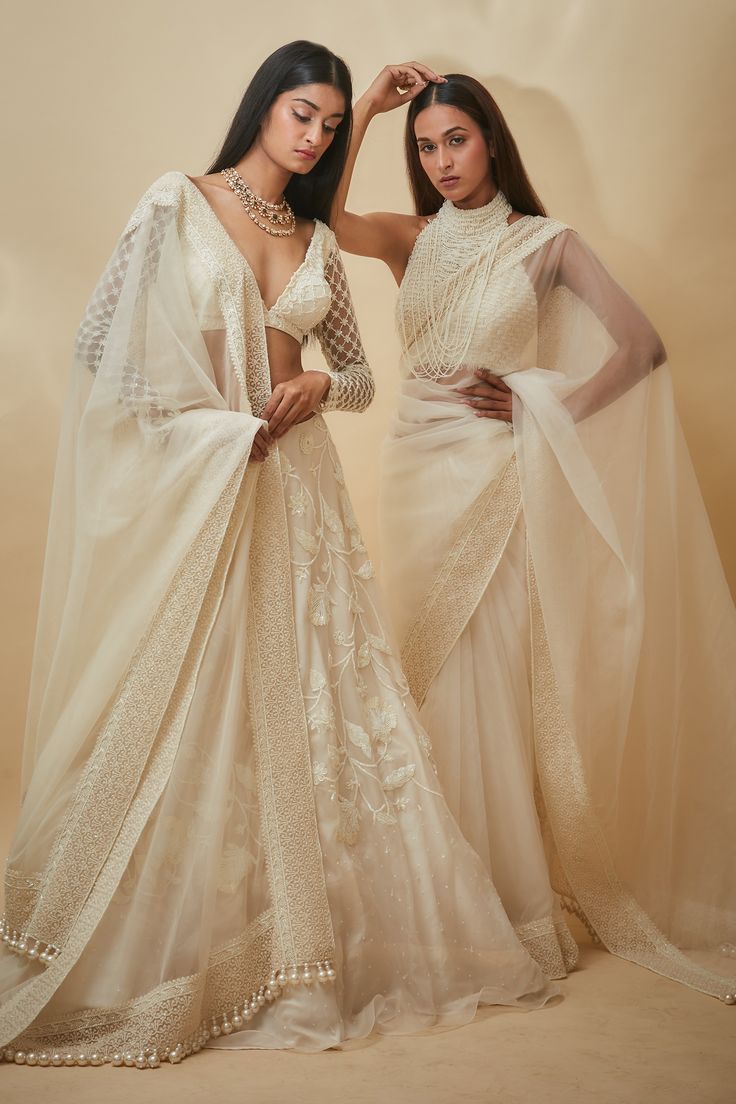 White saree with thread and pearls hand embroidered borders. Comes with a blouse and an underskirt.
Components: 3
Pattern: Hand embroidered
Type Of Work: Thread, Pearls
Neckline: Halter
Sleeve Type: Sleeveless
Fabric: Tulle, Viscose georgette
Color: White
Other Details: 
Heavily embroidered blouse
Closure : Blouse - Back hooks
Note : Lehenga set worn by the other model is not for sale.
Occasion: Wedding - Aza Fashions Festive Wedding Blouse Piece With Pearl Embroidery, Pre-draped Saree With Pearl Embroidery For Diwali Reception, Reception Pre-draped Saree With Pearl Embroidery, Traditional Georgette Pre-draped Saree With Pearl Embroidery, Anarkali Wedding Blouse Piece With Pearl Embroidery, Anarkali Blouse Piece With Pearl Embroidery For Wedding, Semi-stitched Pearl Embroidered Pre-draped Saree, Anarkali Style Wedding Blouse With Pearl Embroidery, Semi-stitched Pre-draped Saree With Pearl Embroidery