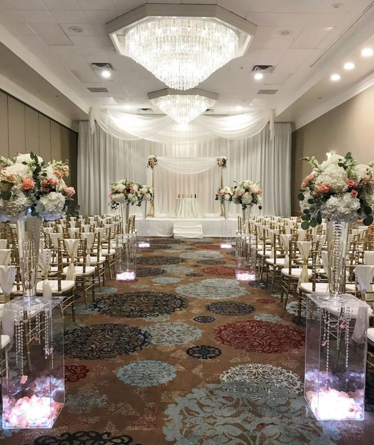 the aisle is lined with clear acrylic chairs and decorated with floral centerpieces