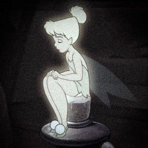 a cartoon character sitting on top of a table with a light shining in the dark