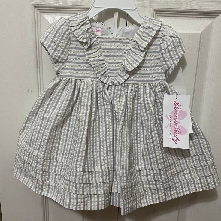 Nwt! Bonnie Jean Flutter Seersucker Dress & Matching Bloomer Size: 3-6 Months Color: Striped Gray, White & Silver Short Sleeved Seersucker Striped Empire Dress Features A Sailor Flutter And Tucked Hem Bundle & Save! Pet Free/Smoke Free Home! N9 Cute Seersucker Dresses With Ruffles, Cute Ruffled Seersucker Dresses, White Cotton Smocked Dress With Ruffles, Cute White Smocked Dress With Short Sleeves, Cute White Seersucker Dress, Spring Seersucker Dress With Ruffles, Striped Ruffle Dress For Playtime, Spring Smocked Dress With Ruffles For Playtime, White Cotton Smocked Dress With Ruffle Hem